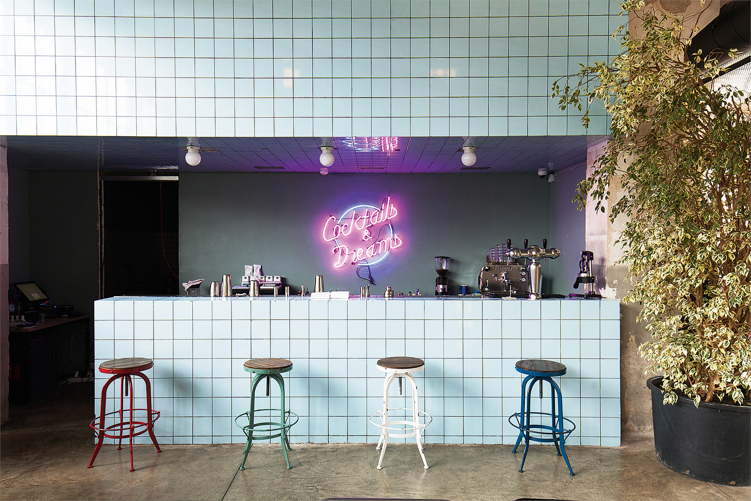 The bar at Fabrika hostel with a cocktails and dreams sign