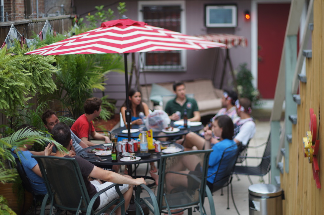 Outdoor patio friends drinking bbq at auberge nola hostel 