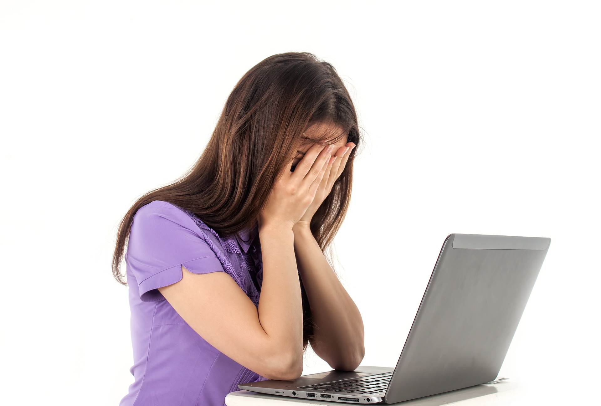 Girl at computer head in hands face covered