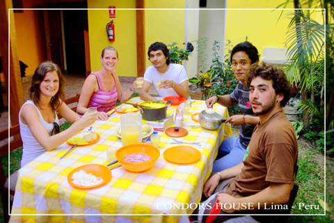 group-emjoy-food-table-condors-house-lima-peru-table-cloth-yellow-wall-plants-people-chair-fire-extinguisher-bowl-plats-jug