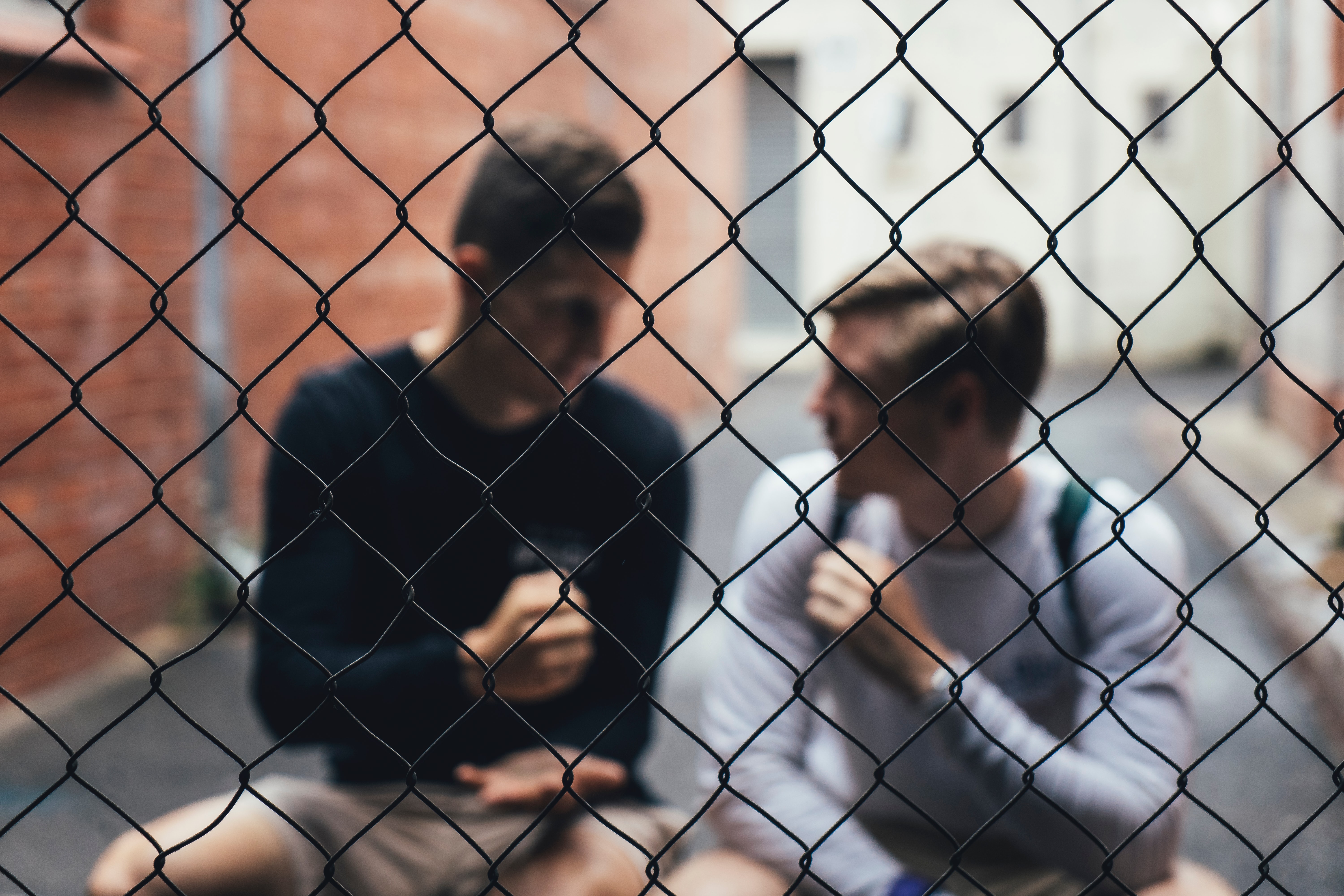 This picture of people playing rock, paper, scissors while behind a fence seemed too fitting, no?