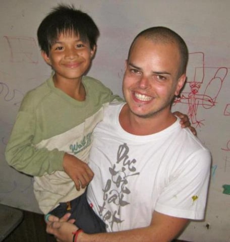 Vin with one of the Cambodian children while volunteering happy smile helping out