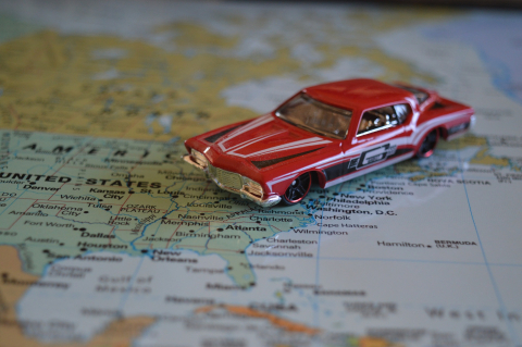 Get ready to learn about US hostels coast to coast! Old American car over US map