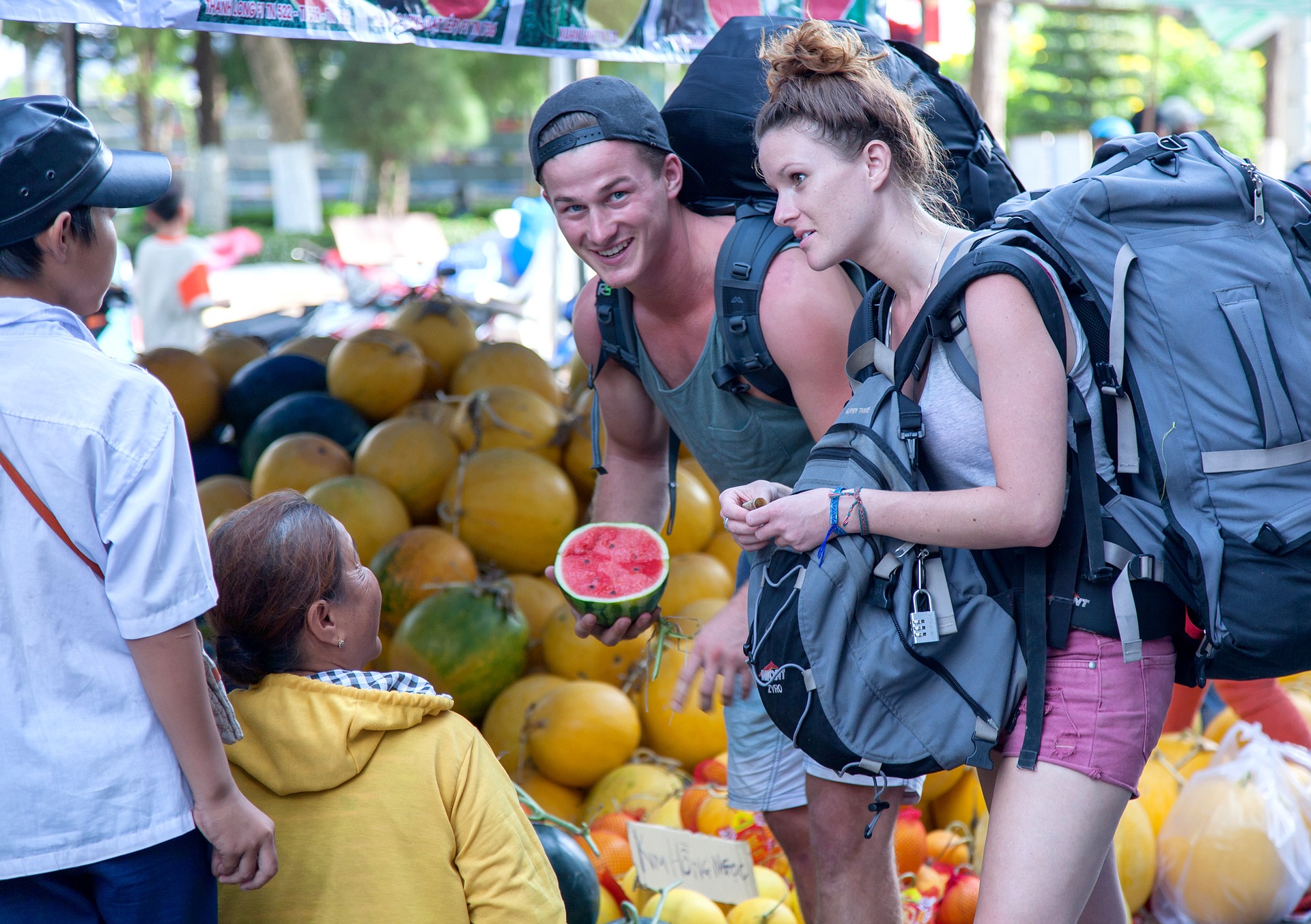 Backpacker man and woman in Vietnam at market with backpacks